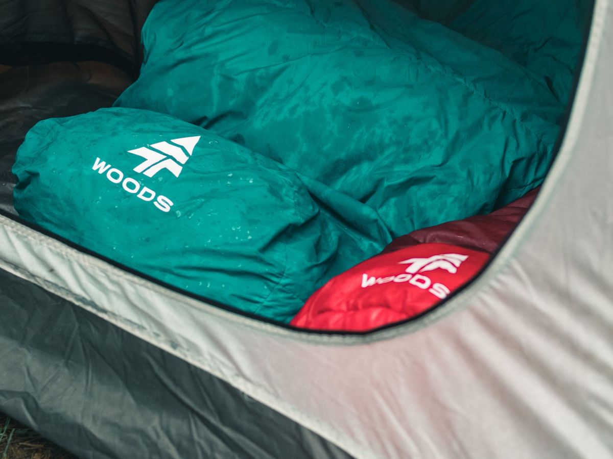 A sleeper in a tent under a mountain sky at first light