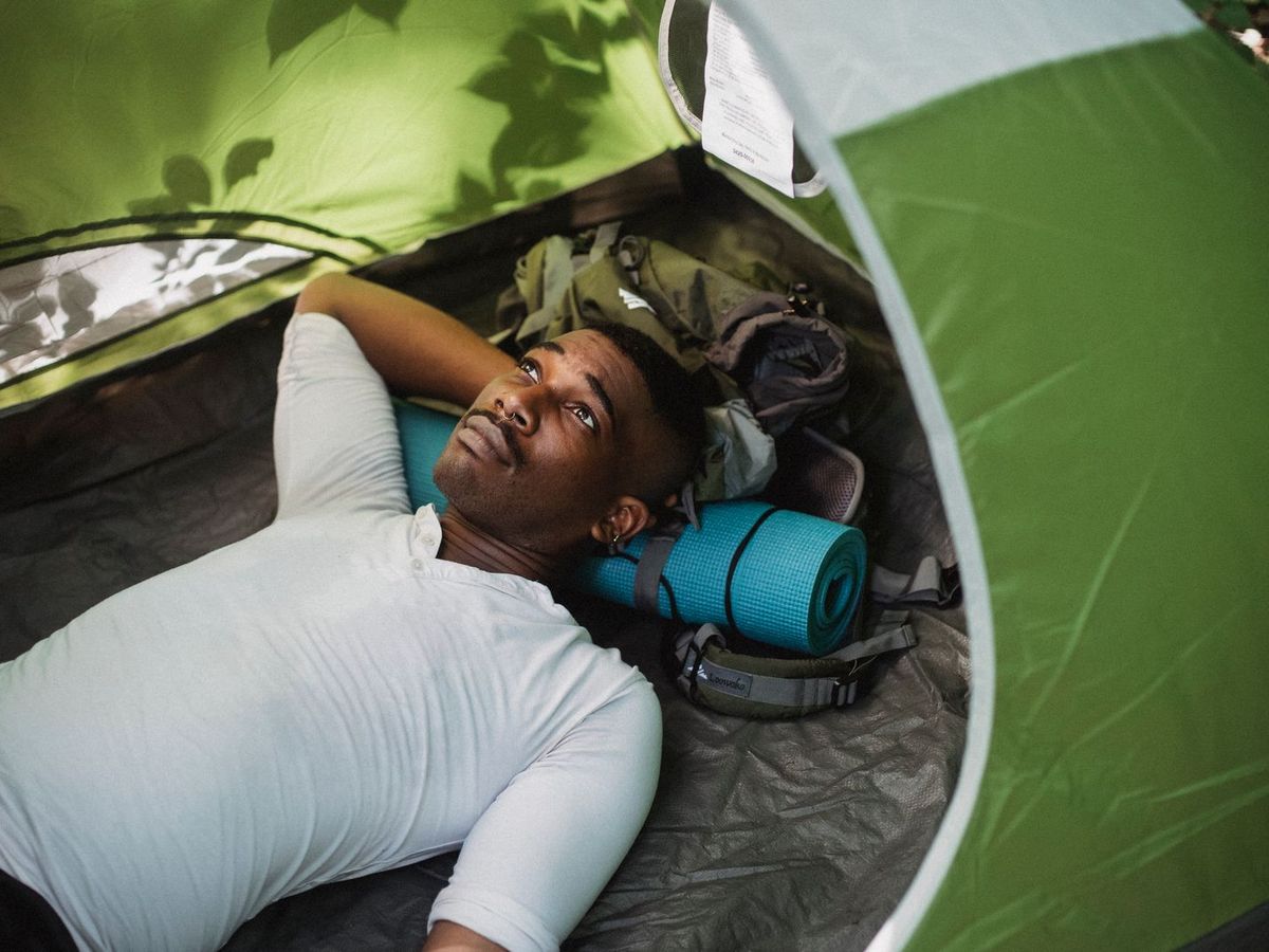Top-down view of a sleeper curled inside a tent