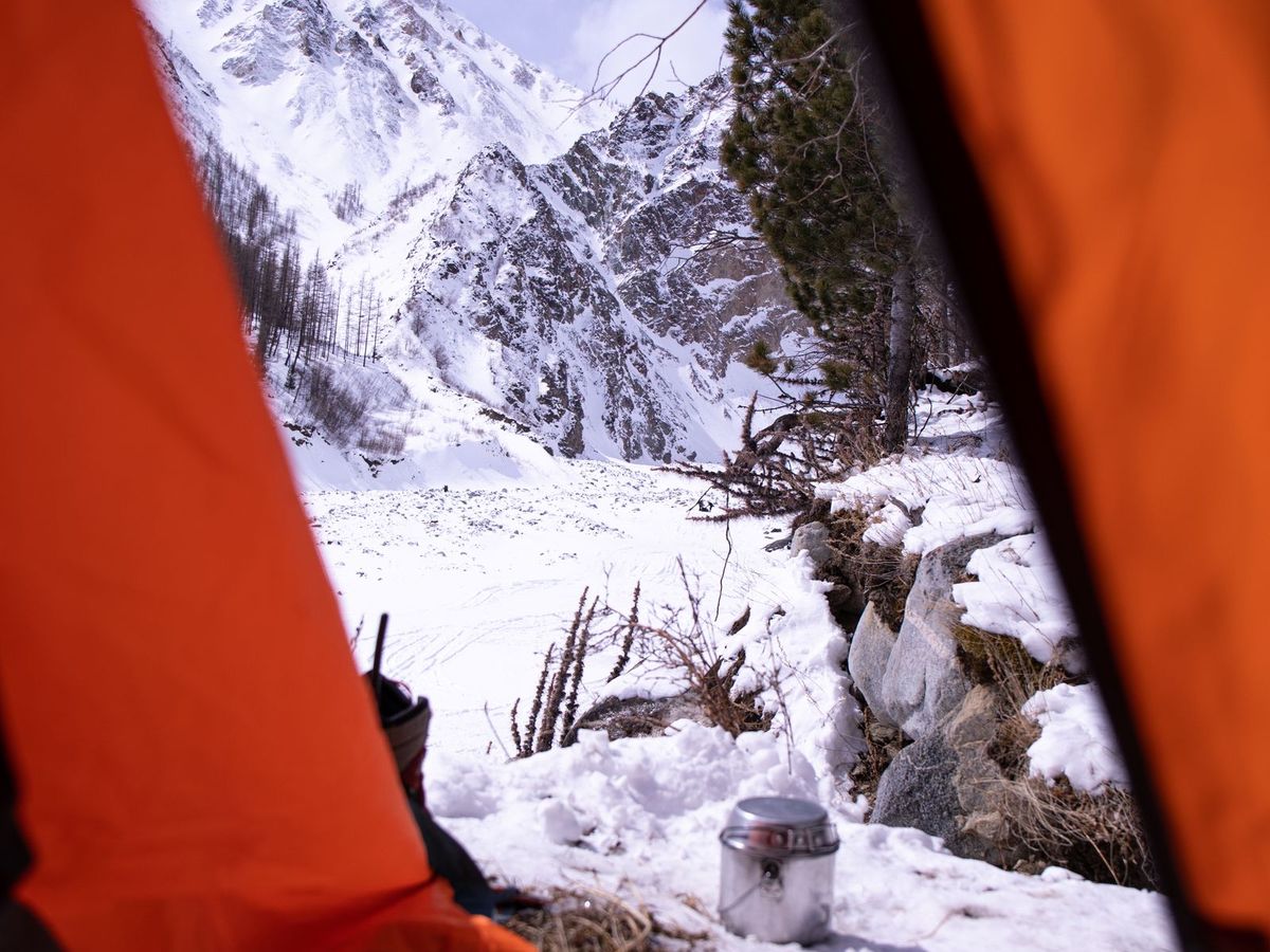 A sleeper in a tent on a high ridge at dusk