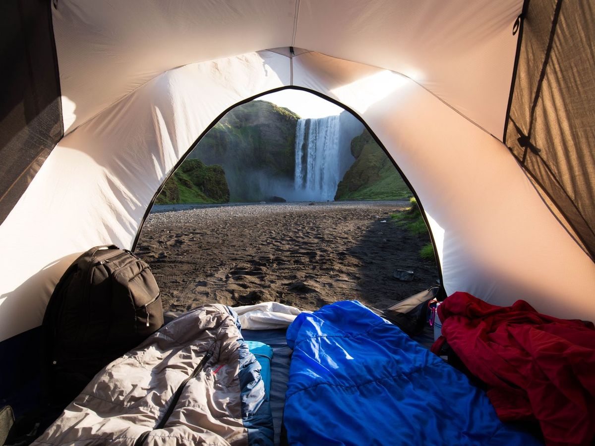 A waterfall seen from inside a tent in wet wilderness